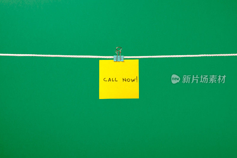 晒衣绳上的黄色纸条上写着“马上打电话!”在彩色背景