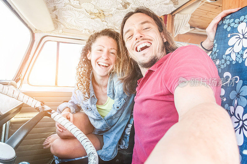 快乐的夫妇在小货车里进行公路旅行-成年人在暑假环游世界的自拍-旅行，科技，爱情和面包车生活理念-关注男人的脸