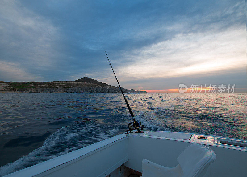 在墨西哥下加利福尼亚卡波圣卢卡斯太平洋边的租渔船上的钓鱼竿的日出视图