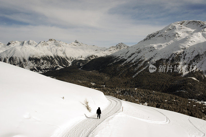 一个人走在雪地上的风景在瑞士的阿尔卑斯山脉