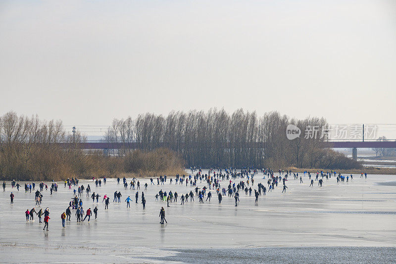 人们在兹沃勒附近的IJssel河边结冰的湖面上滑冰