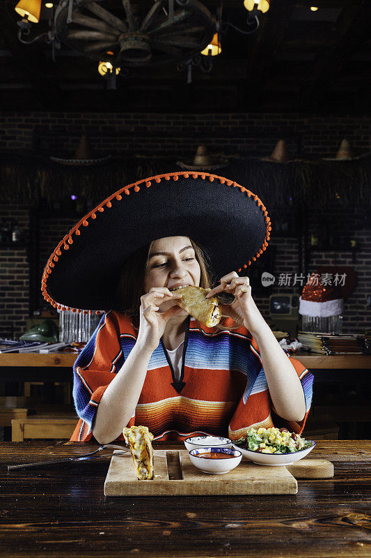 年轻女子吃墨西哥玉米卷