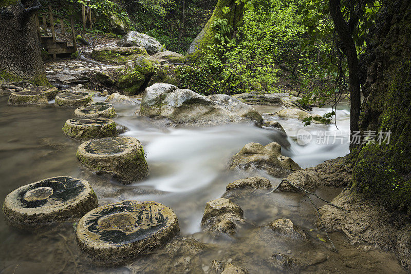 山间溪流在绿树成荫的森林中，长时间的暴露产生了乳白色的水的效果