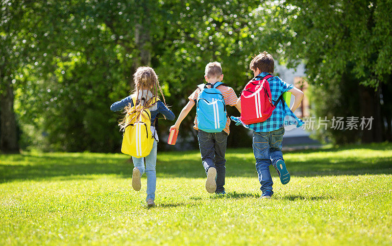 孩子们背着背包站在学校附近的公园里