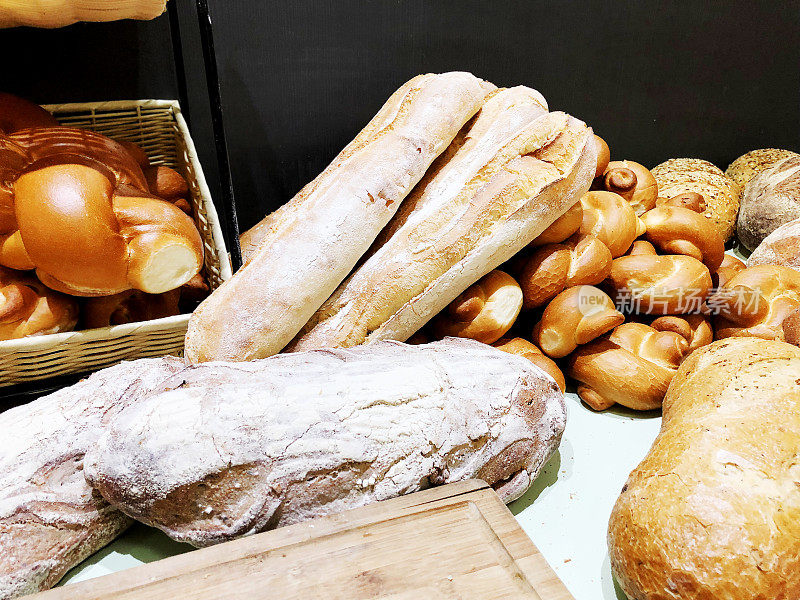桌子上有很多新鲜的面包和小圆面包。面包的业务。面包房里的新鲜谷物和种子做成的面包。