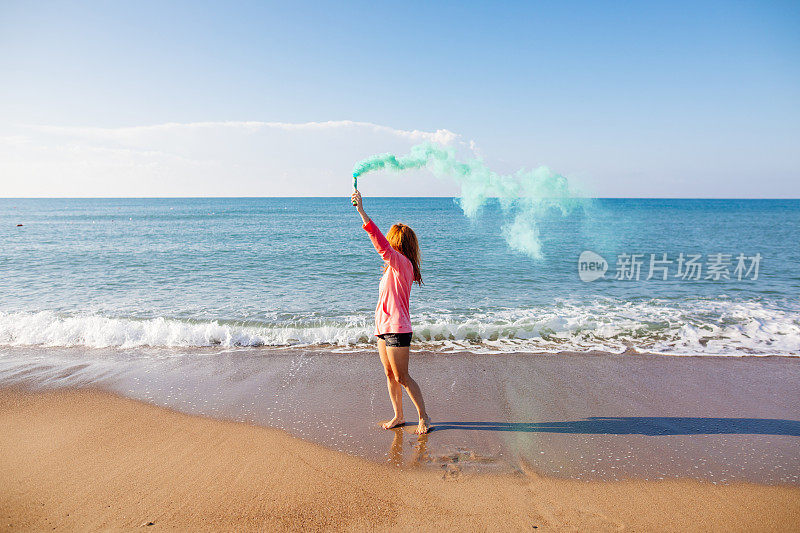 在海滩上玩烟雾弹的女人