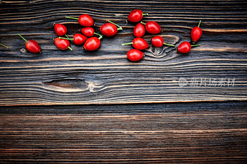木制的背景与秋天的树叶和红色的浆果
