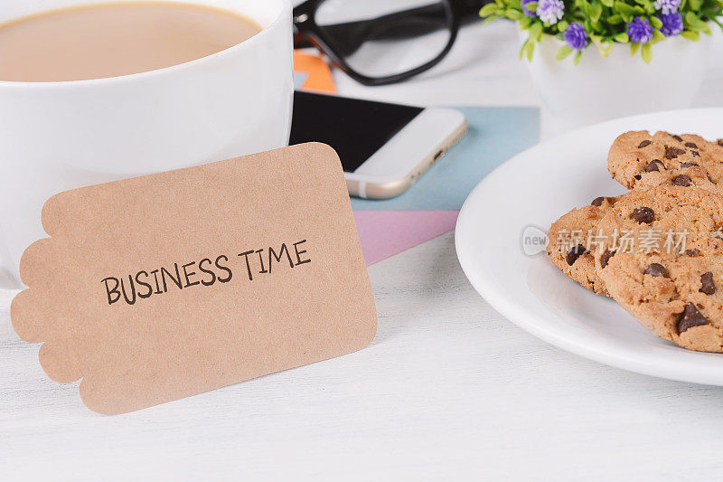 写着“工作时间”的纸质卡片，带手机的咖啡、饼干和眼镜