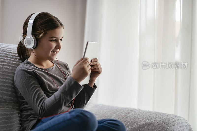 女孩一边用平板电脑一边听音乐