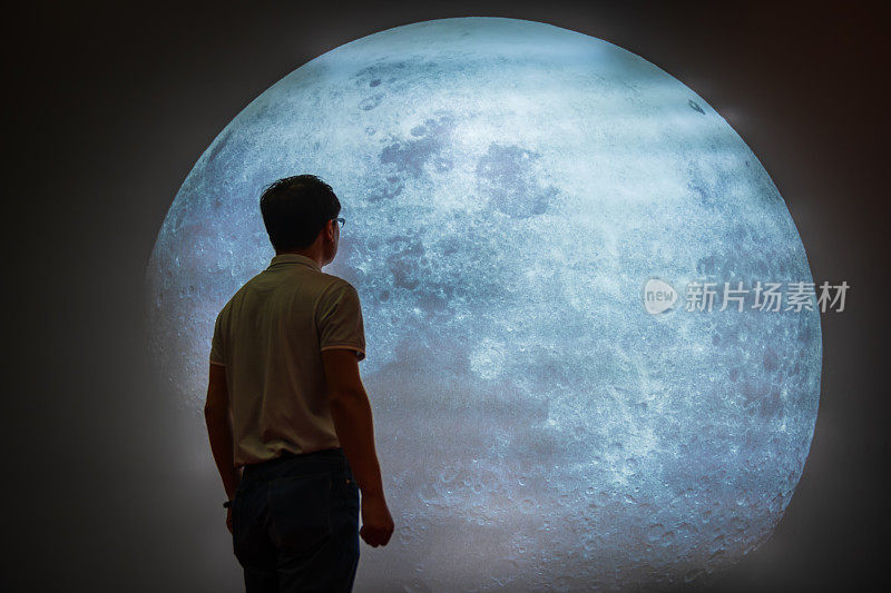 亚洲人仰望夜空中的满月