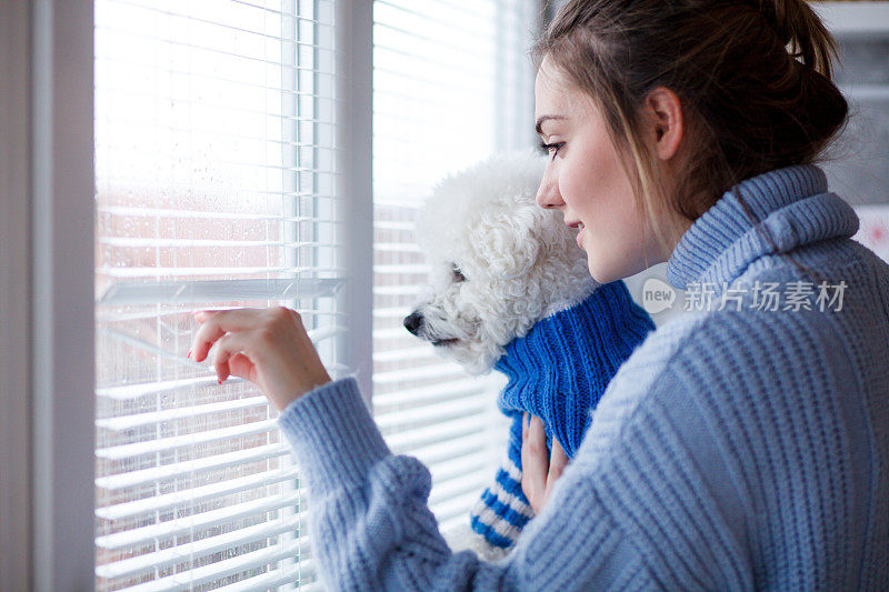 女孩和狗从窗户往外看