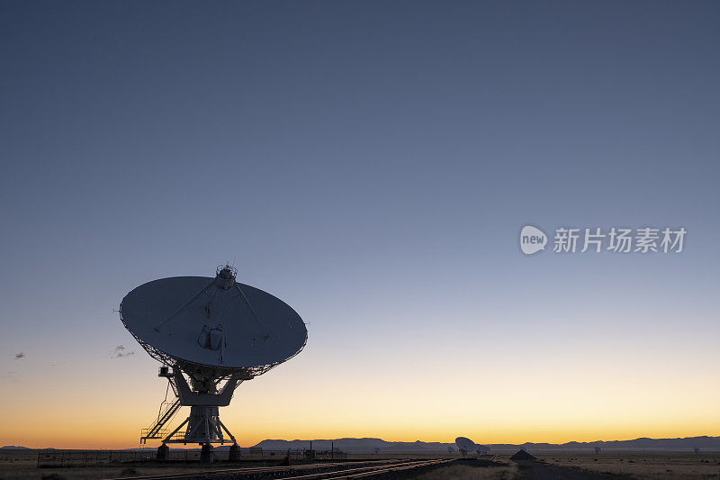 日落天空下的碟形卫星天线