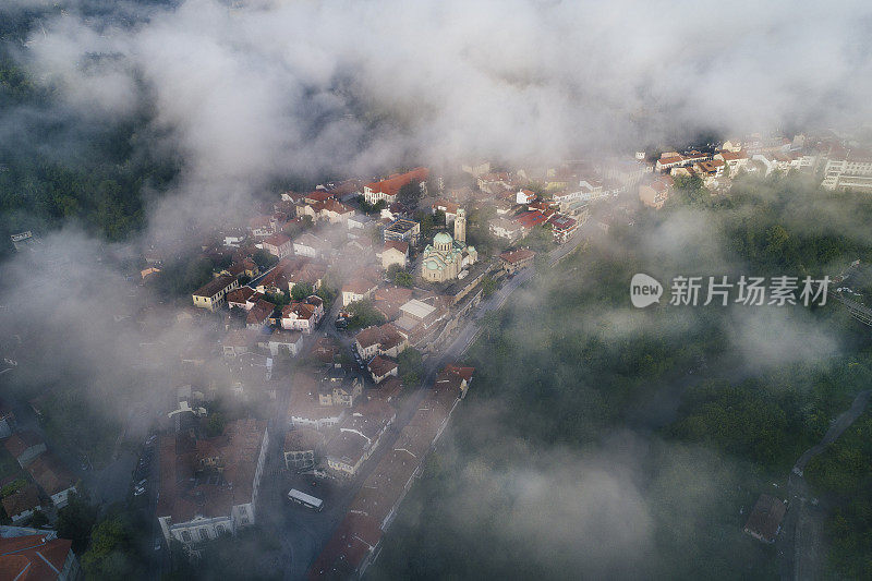 鸟瞰图，一个大城市的景观与浓雾，它醒来，从上面看日出，晨雾