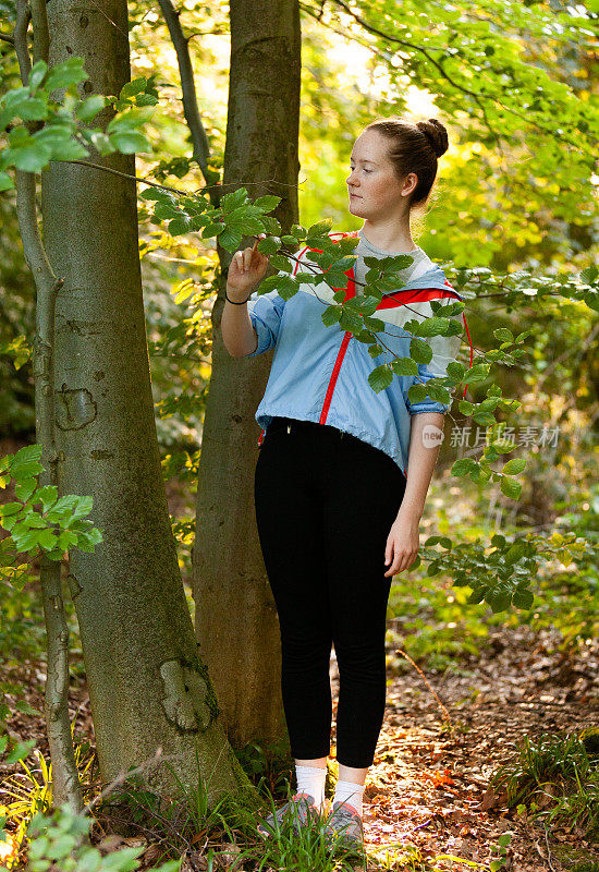 十几岁的女孩在树林里，对自然感兴趣，在树林里