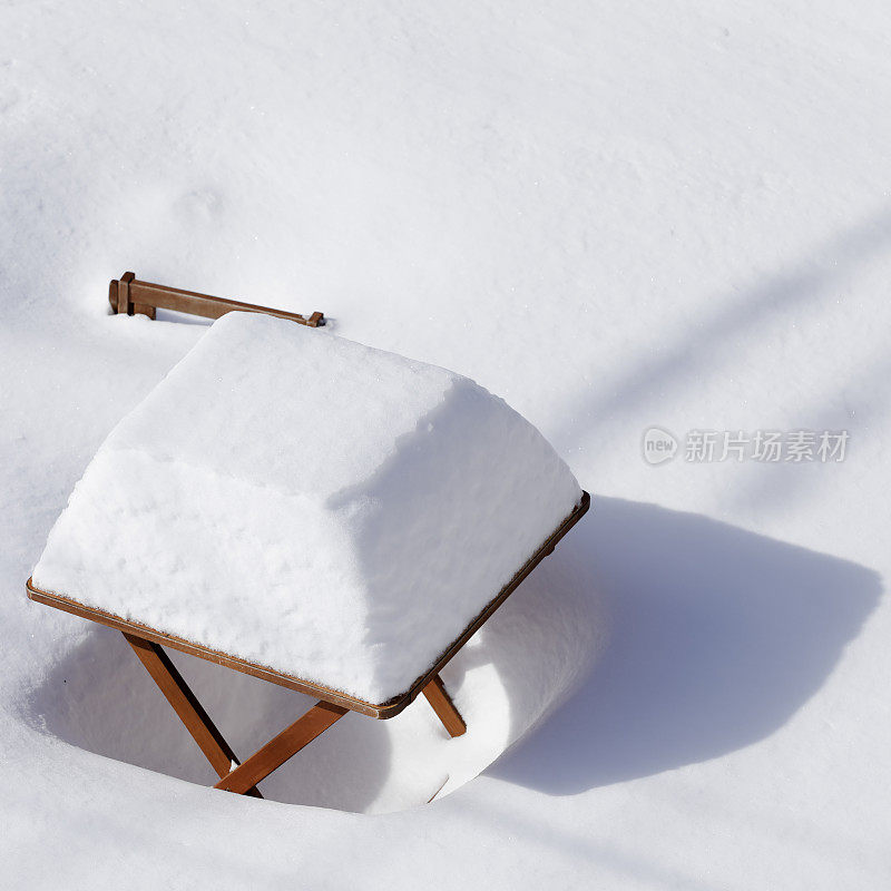 蒙特利尔的花园，桌子和椅子被雪覆盖