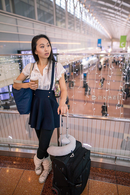 一名亚洲女子在机场候机区等候