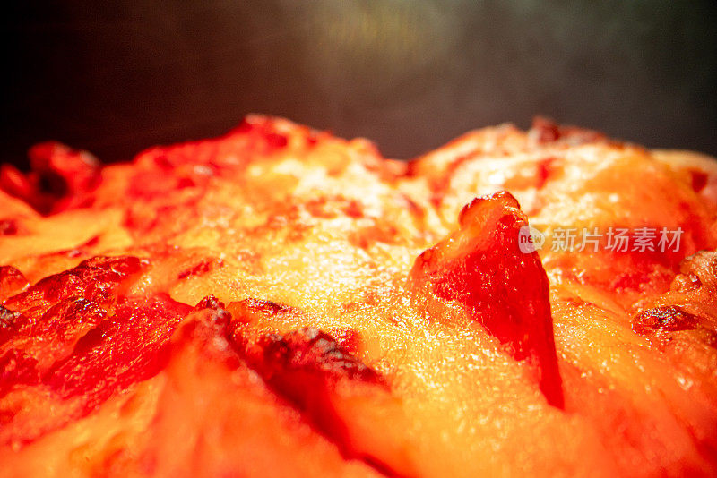 超近距离广角微距拍摄的辣香肠在一个美味的热气腾腾的深盘辣香肠披萨新鲜出炉的烤箱在冷却架下的加热灯与复制空间