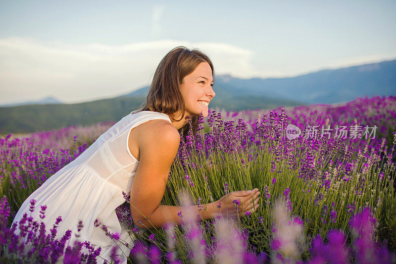 美丽的年轻女子在薰衣草地里享受