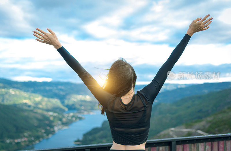 女人享受自由的旅行，张开双臂拥抱大自然