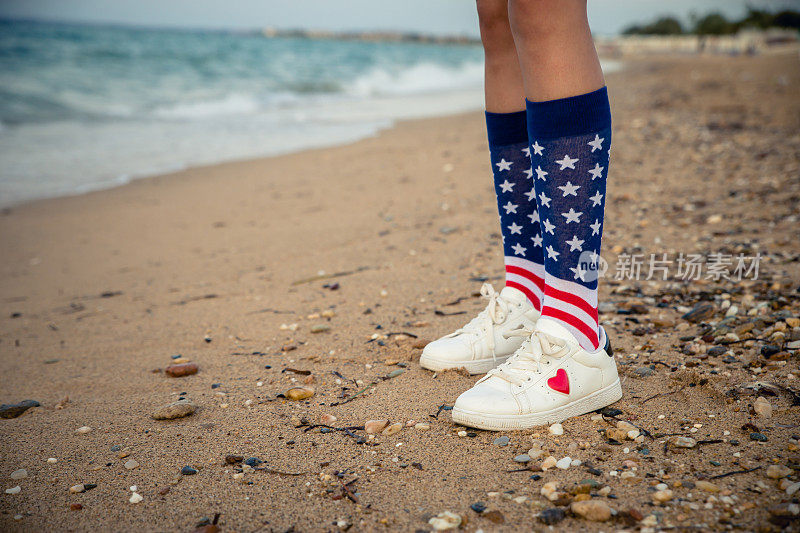 女人穿着印有美国国旗的袜子在海滩上