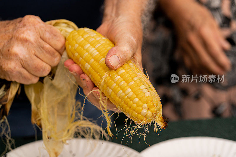 男人打开了一个新鲜的烤玉米