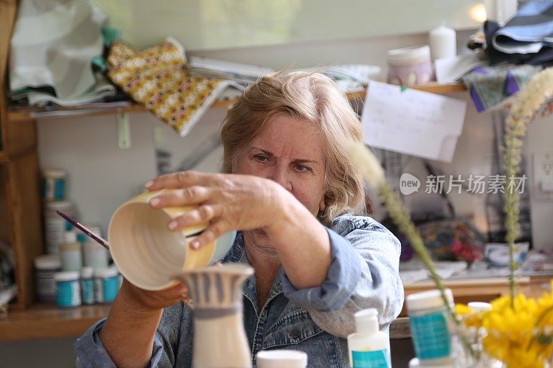 退休妇女在她的作坊里制作陶器