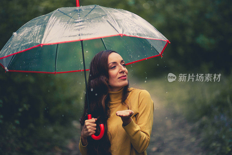 美丽的年轻女子享受着雨天