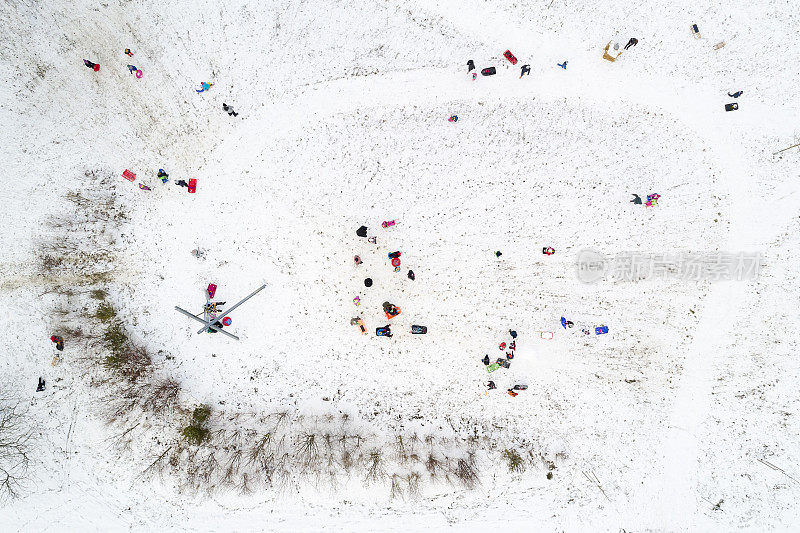 鸟瞰图的孩子和家长坐雪橇在冬日