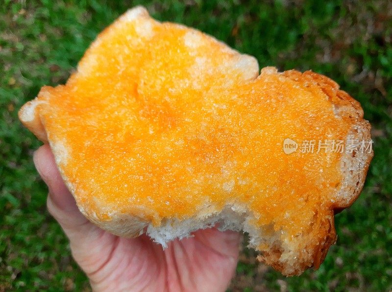 手握甜吐司黄油面包-曼谷街头食品。