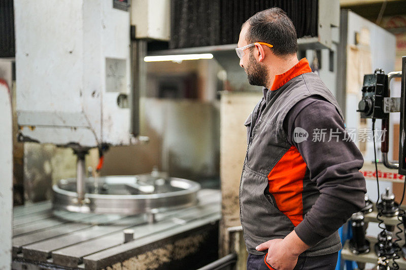 男技师在工业数控机床上检查零件