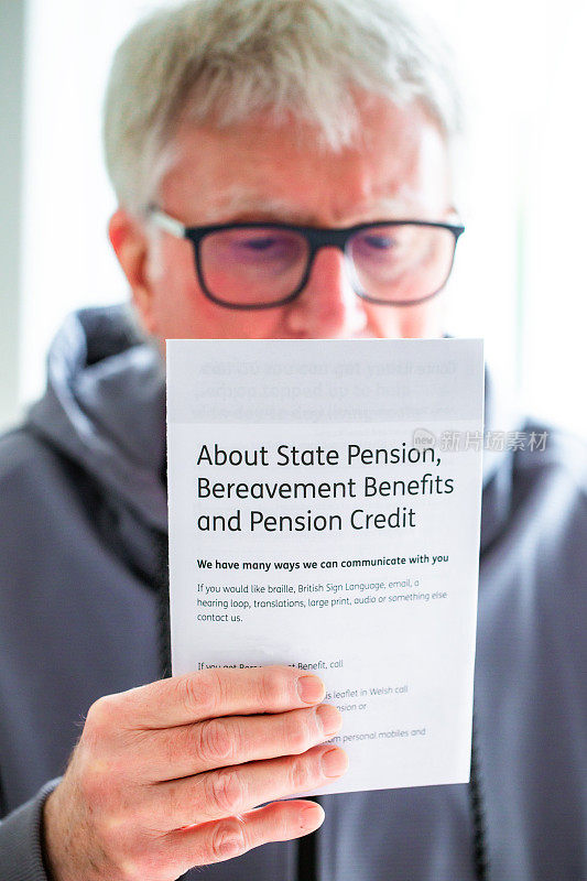 退休老人阅读有关国家养老金的传单