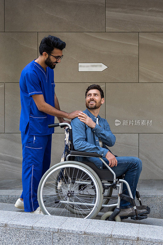 黑发男护士带着坐轮椅的病人散步