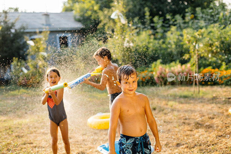 炎热的夏日，孩子们在院子里打水仗