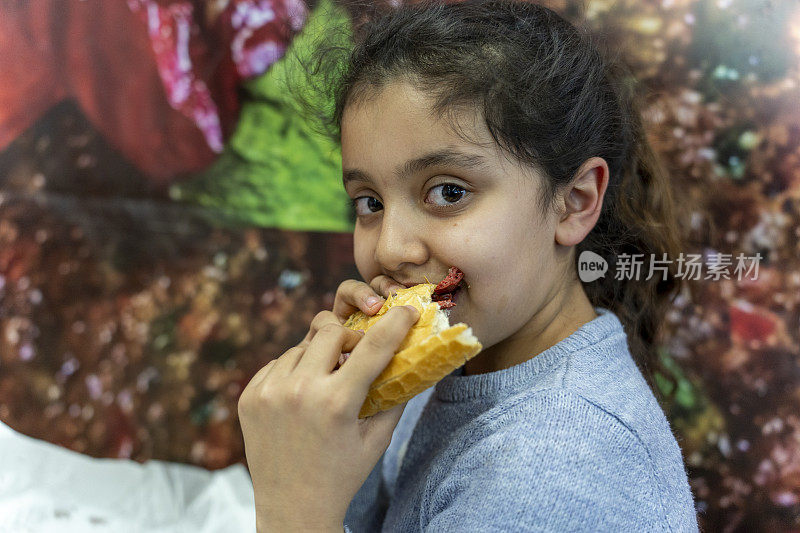 一个女孩在吃三明治。