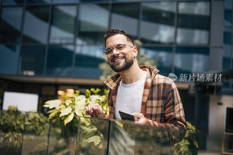 一名男子在街上用智能手机发信息。