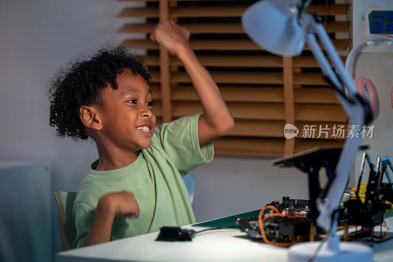 一名非洲少年得意地举起手，为自己发明了一种新代码，能让他的机器人汽车跑得更快而兴奋不已。一个年轻学生在STEM领域取得成功的兴奋和满足，展示了他的好奇心、智慧和创造力
