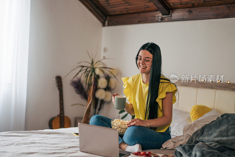 一个小女孩正在一边看电影一边吃零食。