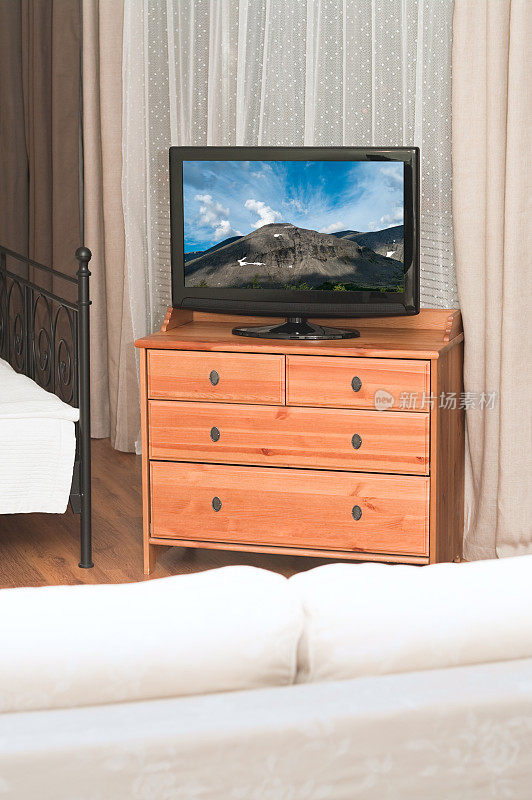 房间里有一台大电视机，前面是白色的沙发