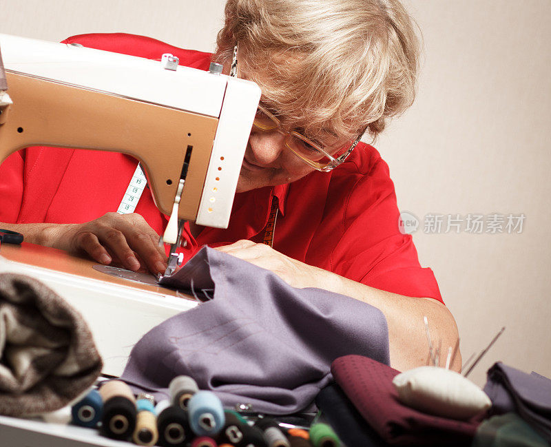 老妇人用缝纫机缝纫