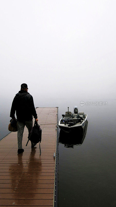 纽约的萨拉纳克湖，雾蒙蒙的早晨，渔夫从码头走到船上
