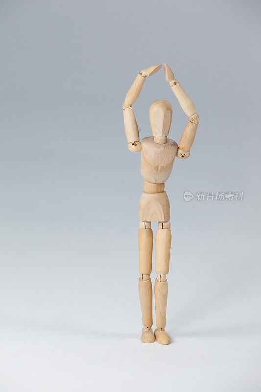 举起双手站立的木制雕像