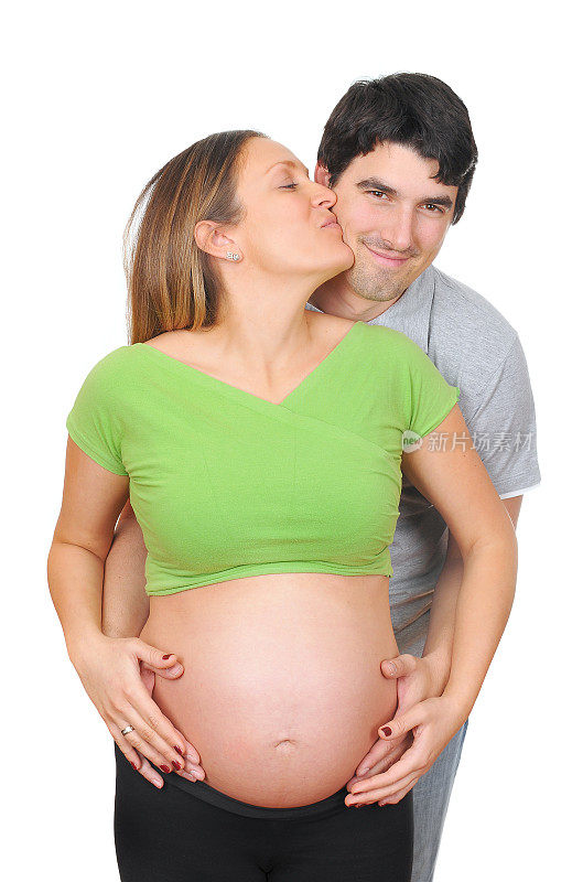 怀孕的白人女人赤裸着肚子亲吻她的丈夫