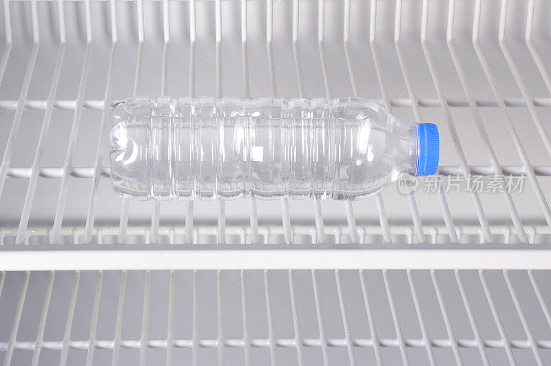 冰箱架子上的一个塑料水瓶