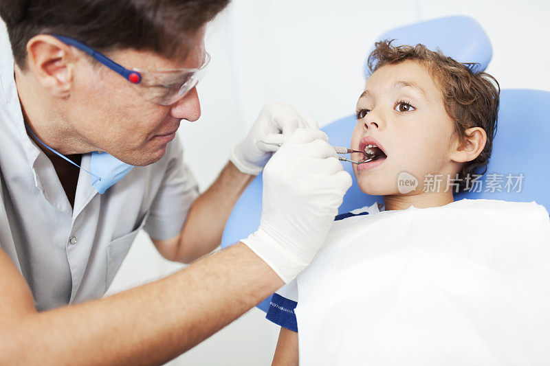 牙科医生张开嘴巴检查孩子。