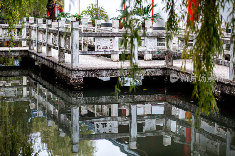 一座中国花园中池塘上的石桥