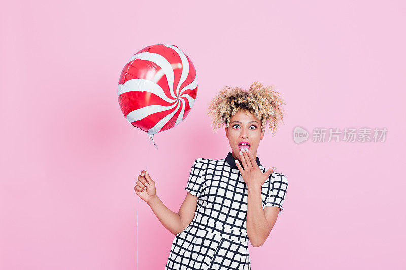 一个拿着糖果气球的美国黑人年轻女子