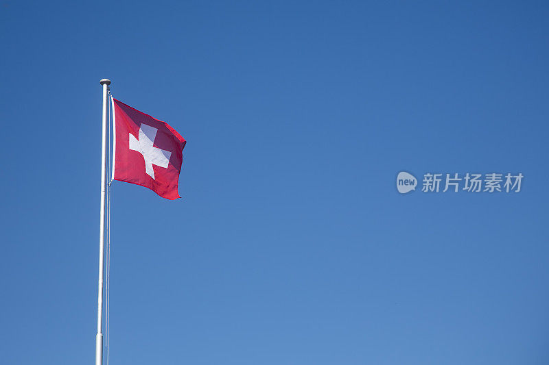 瑞士国旗迎风飘扬在蓝天前