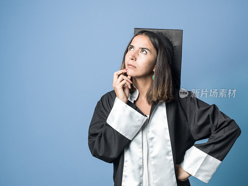 凝视着穿着毕业礼服拿着毕业证书的漂亮女人