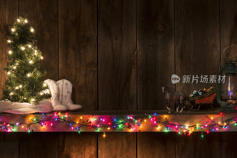 西方节日的壁炉架配有灯、树、雪橇、靴子和谷仓木背景