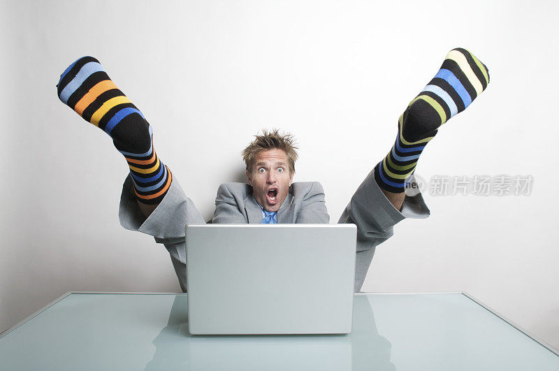 一名商人在他的电脑前穿袜子